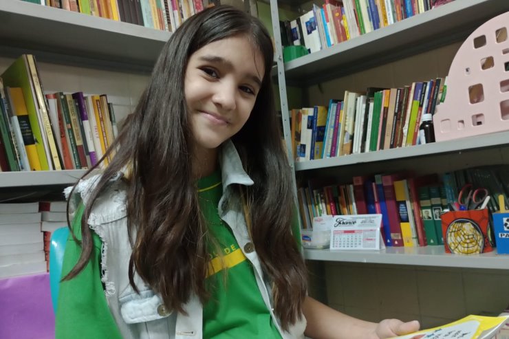 Imagem: Comunicativa, Marielly Brandão, de 12 anos, ama livros e conta que viaja na imaginação sempre que tem uma história nas mãos