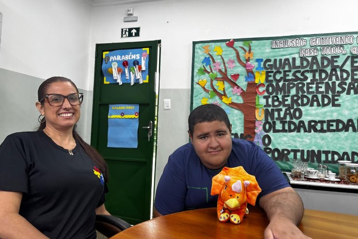 Imagem: Professora Adriana, Kaleb, adolescente autista, e seu inseparável dinossauro de pelúcia