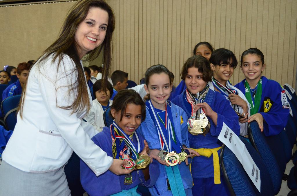Imagem: Mara ao lado de jovens que ganharam medalhas para o Estado